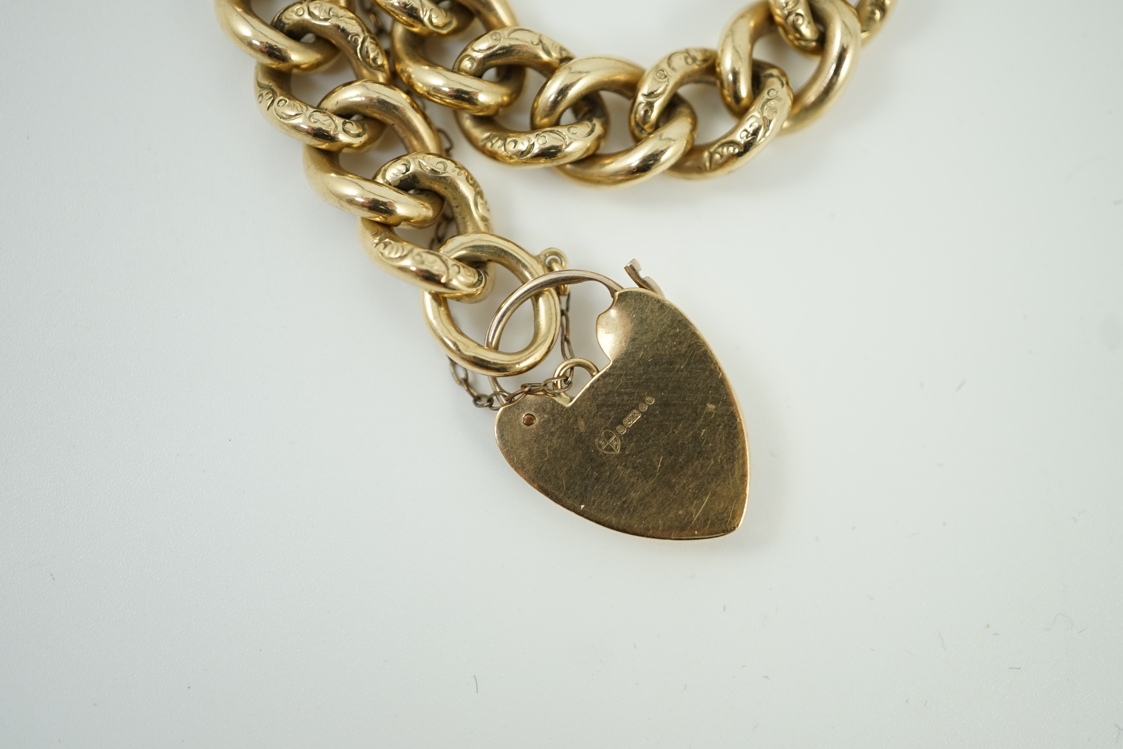 An engraved 9ct gold curb link bracelet, with heart shaped padlock clasp, approx. 18cm, 51.3 grams.